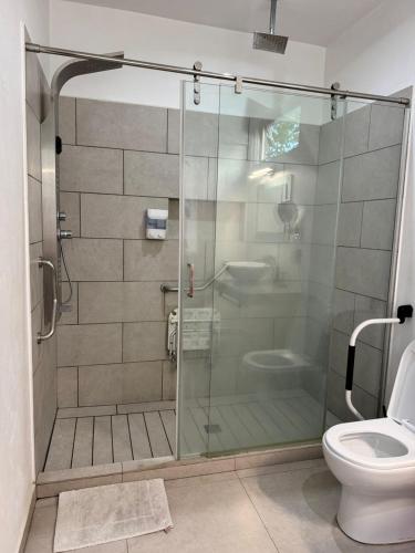 a bathroom with a glass shower with a toilet at Vistas del Angel in San Juan Cosalá