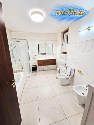 a bathroom with two toilets and a tub and a sink at Il Mulin Dell'Architetto in Fornaci di Barga