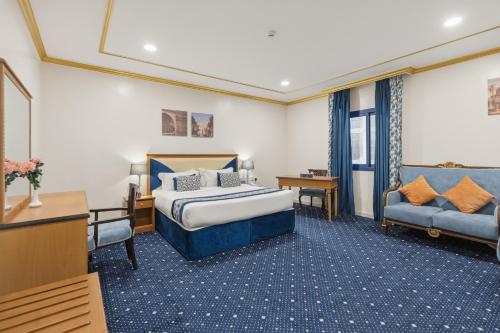a hotel room with a bed and a couch at Amjad Al Deafah Hotel in Mecca