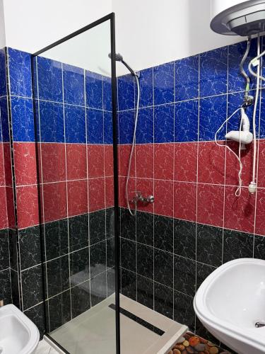a bathroom with a glass shower stall and a toilet at Sea You Soon Apartment in Shëngjin