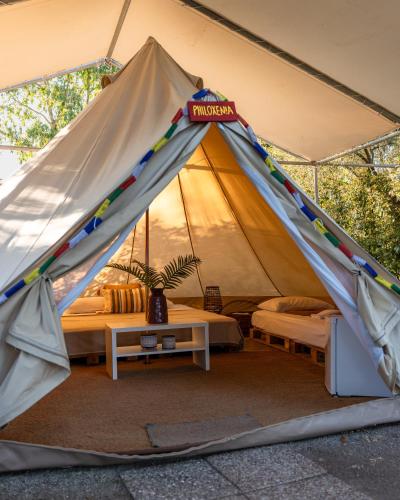 a tent with a bed and a table in it at Nisi Glamping in Paralia Rachon