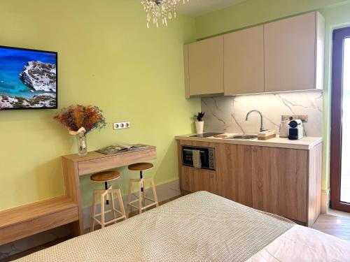 eine Küche mit Spüle und zwei Hockern in einem Zimmer in der Unterkunft Rozmari and Spa in Agia Galini