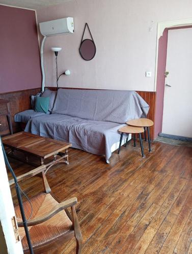 a living room with a bed and a table at Maison de campagne in Maussac