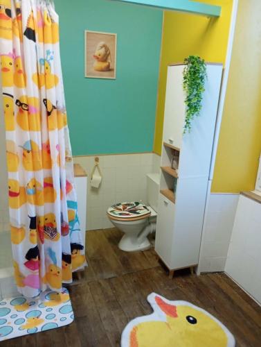 a bathroom with a toilet and a shower curtain at Maison de campagne in Maussac