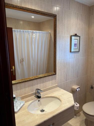 a bathroom with a sink and a toilet and a mirror at El Ancla in Laredo