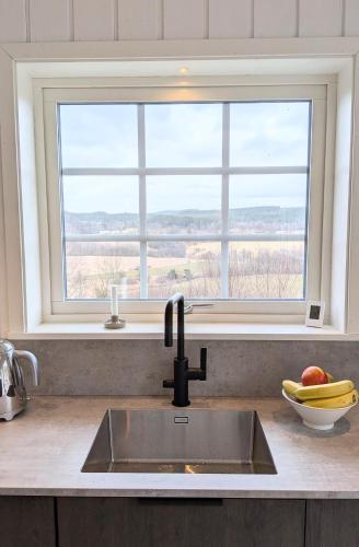 a kitchen counter with a sink and a window at Backahöjd Holidays in Rävlanda