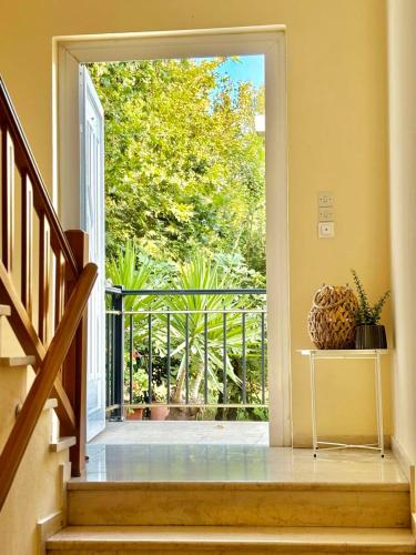 an open door leading to a balcony with plants at Fuji Hotel in Edipsos