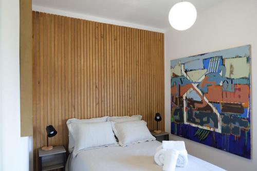 a bedroom with a bed with a painting on the wall at AL Penedo da Cheira in Penacova