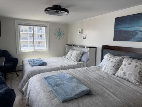 a bedroom with two beds and a window at Salty & Sweet 303 in Old Orchard Beach