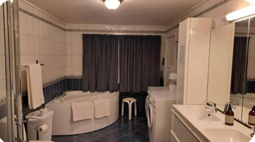 a bathroom with two sinks and a tub and a toilet at Rolig sted ved havet in Sirevåg