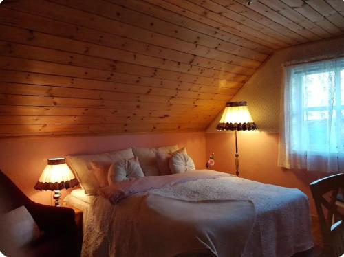 a bedroom with a large bed with two lamps at Rolig sted ved havet in Sirevåg