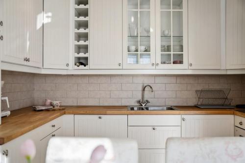 a white kitchen with white cabinets and a sink at The Reine Scenic View in Moskenes