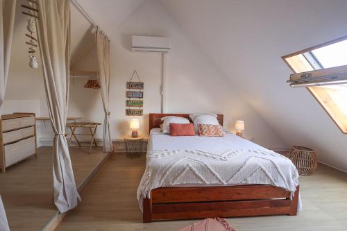 a bedroom with a large bed in a attic at Duplex vue mer - piscine - 5 min des plages in Le Gosier