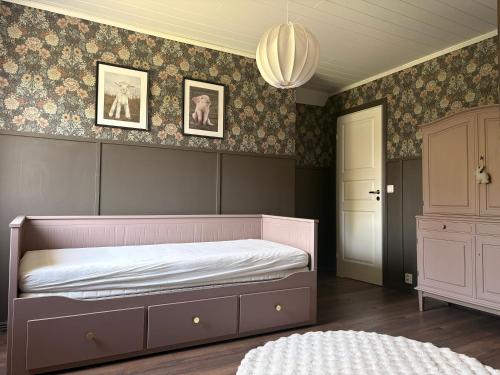 a bedroom with a pink bed and a dresser at Hus Orsa in Orsa