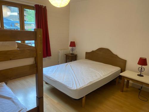 a bedroom with two bunk beds and a window at Le fleuri ensoleillé de Guzet in Ustou