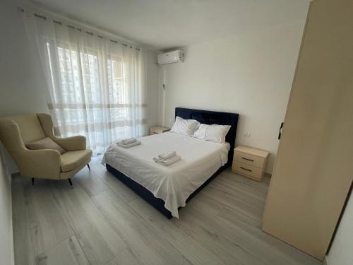 a bedroom with a bed and a chair and a window at Golem Apartments in Golem