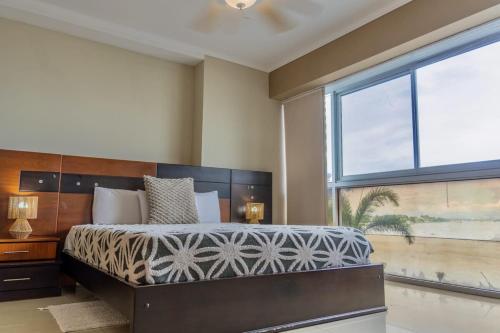 a bedroom with a large bed and a large window at Puerto Santa Ana, river view 102 in Guayaquil