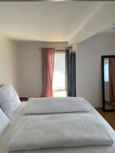a bedroom with a large white bed with a window at Pension Victoria in Millstatt