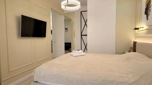 a bedroom with a bed with a flat screen tv on the wall at Status center in Bălţi