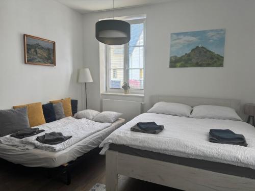 two beds in a bedroom with towels on them at Apartmán Augustin Jičín in Jičín