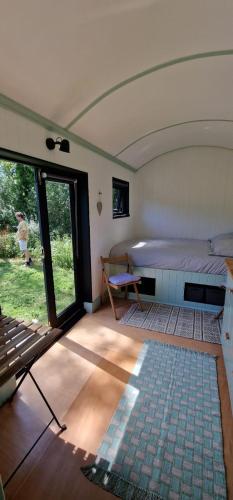 a room with a bed and a table in it at Apple Orchard Shepherd Huts in Staple Cross