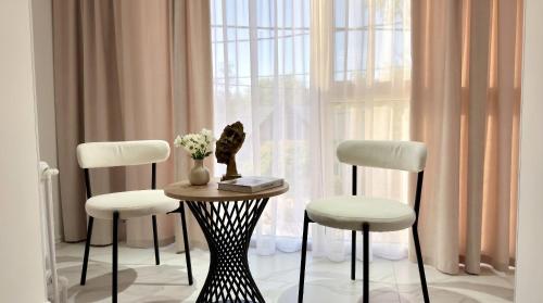 a table with a cat sitting on it next to two chairs at Status center in Bălţi