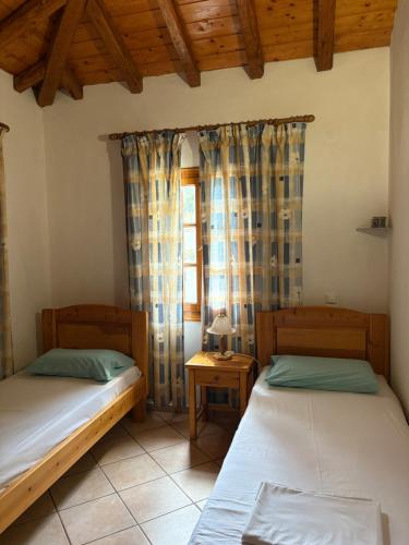 two beds in a room with a window at Villa Amfithea in Skiathos