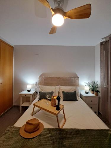 a bedroom with a bed with a ceiling fan and a table at kalma in Moncófar