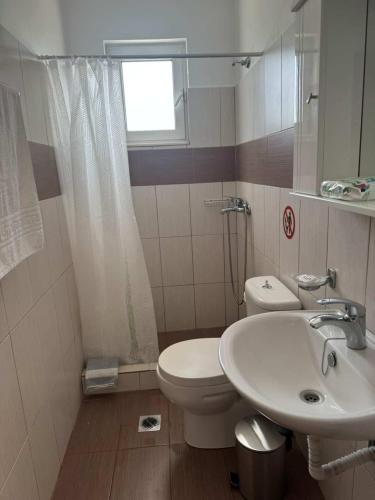 a bathroom with a sink and a toilet and a window at Zografos 5 in Haraki