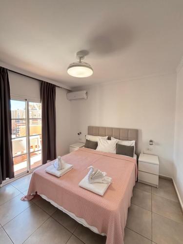 a bedroom with a large bed with two towels on it at Yucca Park ApartHotel in Adeje