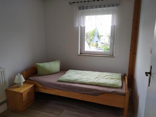a small bedroom with a bed and a window at Ferienwohnung Schwerg in Hohnstein
