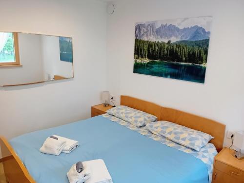 a bedroom with a bed with two towels on it at Appartamento Miele di Pino in Ziano di Fiemme