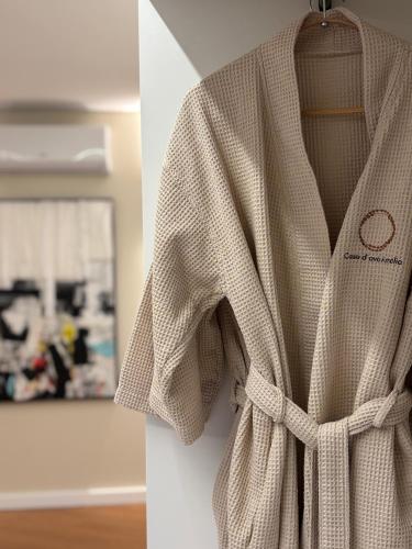 a white robe is hanging on a wall at Casa D'avó Amália in Travanca