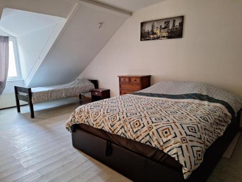 a bedroom with a bed and a dresser in a attic at Ô Cottage La Barre Ormesson - 20 min Paris in Deuil-la-Barre