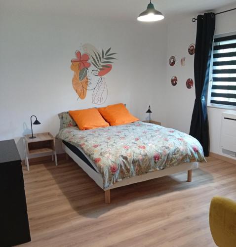 a bedroom with a bed with orange pillows on it at Maison de campagne in Capelle-Fermont