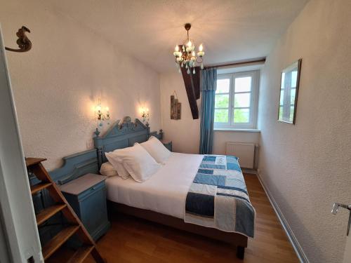 a bedroom with a blue bed and a window at Domaine de Fondain in Laqueuille