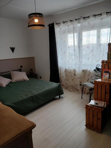 una camera da letto con un letto verde e una finestra di La Ferme a Arinthod