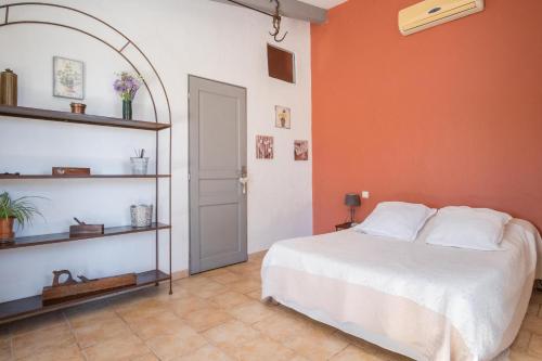 a bedroom with a bed and an orange wall at Le Bouquet de l Aromate in Joucas