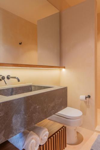 a bathroom with a sink and a toilet at Luxury Penthouse, Rooftop Pool and Lagoon in Bacalar