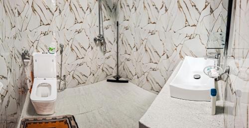 a bathroom with a white toilet and a sink at Nice View Guest House & Restaurant in Ella