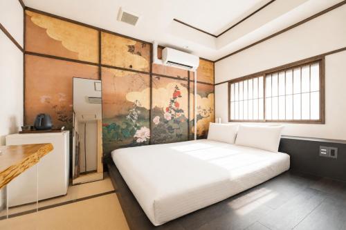 a bedroom with a white bed and a wall at OYASUMI Art HOTEL Dotonbori 24-Hour Check-in Pressure-relief mattress in Osaka