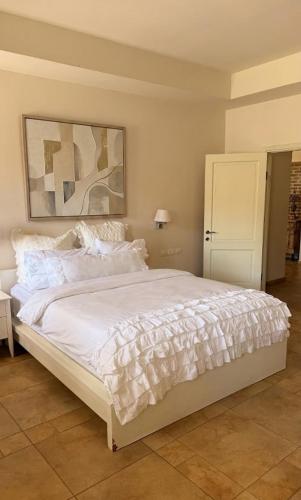 a bedroom with a large bed with white sheets at נורית בעמק in Gan Yoshiyya