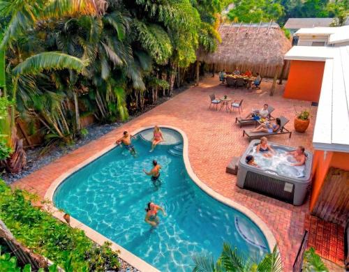 a group of people playing in a swimming pool at Hidden Gem Vacation Villa w Private Pool & TikiHut in Fort Lauderdale