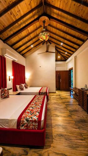 a bedroom with two beds in a room with wooden ceilings at Gatetrees resort in Jaffna
