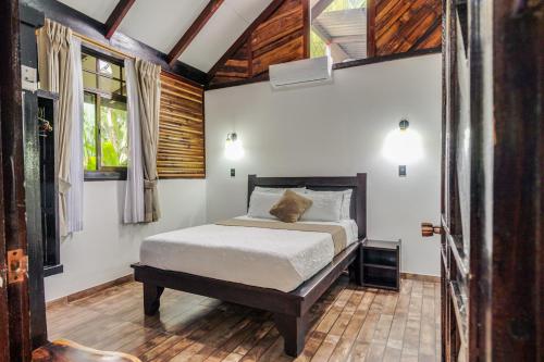 a bedroom with a bed in a room with wooden ceilings at Casa Shaquir H -Luxury Villa with Private Pool & Stunning Views in Puerto Viejo