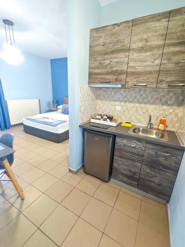 a kitchen with a sink and a room with a bed at Celeste Deluxe Apartments in Skala Potamias