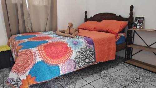 a bed with a teddy bear laying on it at Buganvilla No 4 Aire acondicionado in Quepos