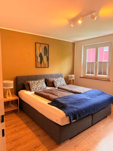 a bedroom with a large bed with a blue blanket at Ferienwohnungen Bohner/Wohnung Elisabeth in Meersburg