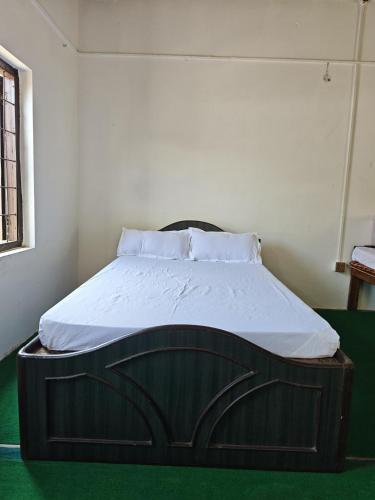 a bed with a wooden frame in a room at Gatlang Backpackers in Trisūli Bāzār