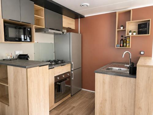 a kitchen with a stainless steel refrigerator and a sink at Au 7cent14 in Marcilly-sur-Eure